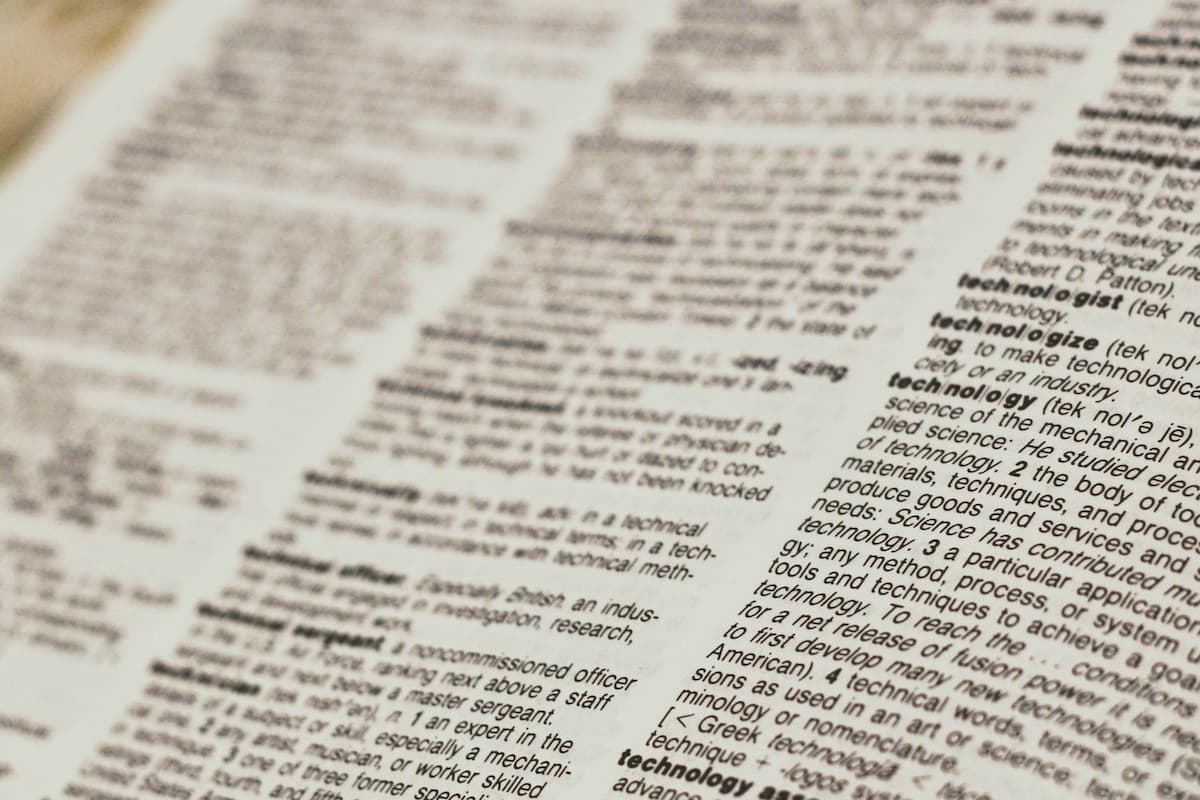 Close-up of dictionary pages with financial terms and definitions highlighted, providing a visual representation of key terms like APR, APY, and Amortization for better understanding.