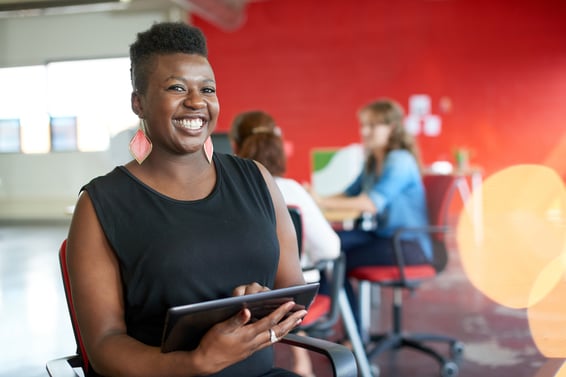 Confident female designer working on a digital tablet in red creative office space-1