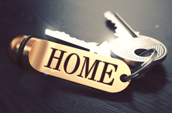 Keys and Golden Keyring with the Word Home over Black Wooden Table with Blur Effect. Toned Image.