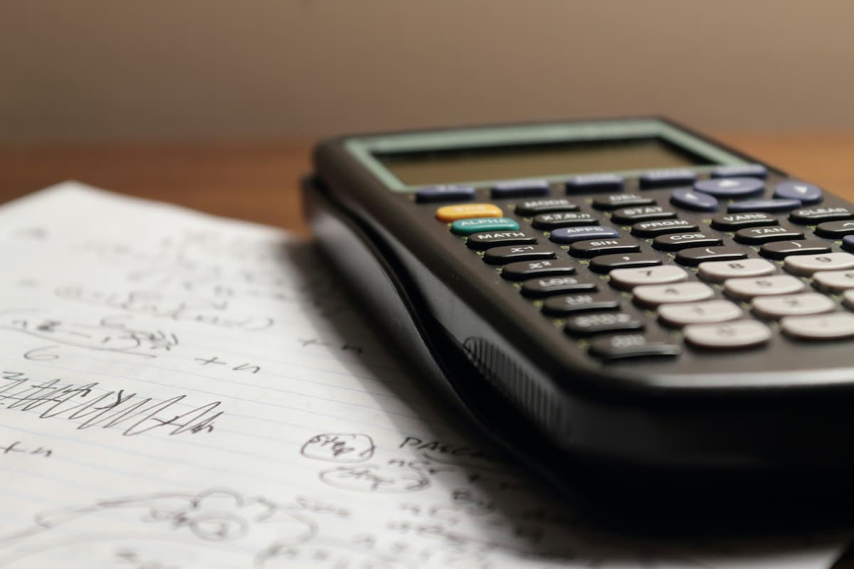 A close-up of a calculator and financial documents used for calculating real estate investment cash flow, emphasizing financial analysis and planning for property investors.