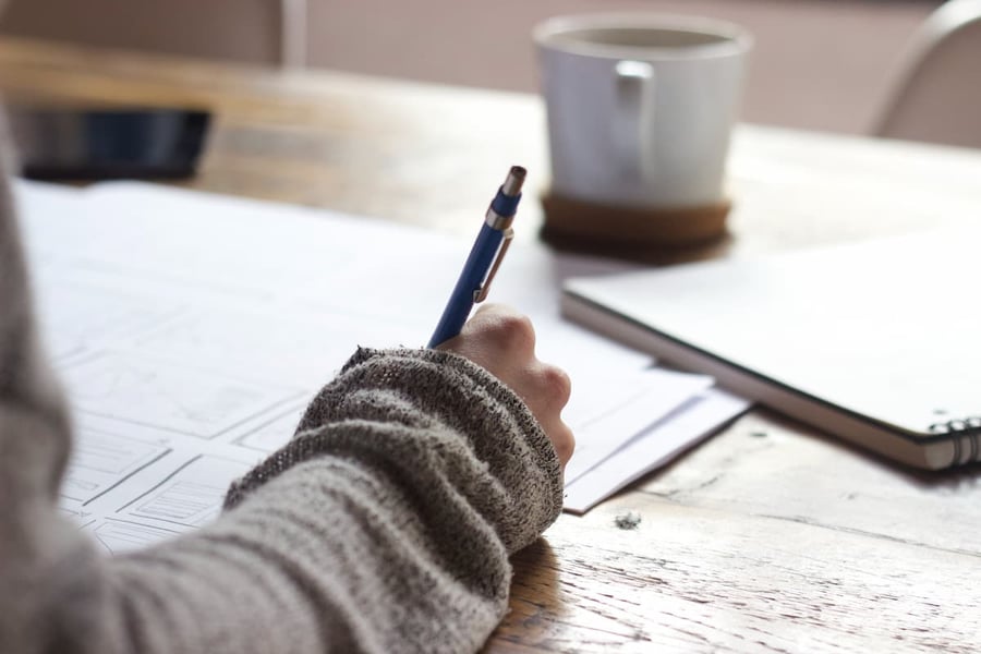 Business owner filling out a commercial loan application form with organized documents on a desk.